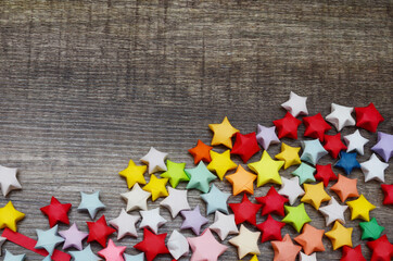 Wall Mural - Colorful handmade lucky stars on wooden background