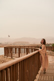Fototapeta  - Pretty woman posing in Egypt hotel. Young caucasian woman in black swimsuit and golden dress