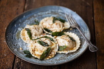 Wall Mural - Home made pumpkin ravioli with crispy sage leaves and pinenuts