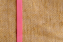 Pink Ribbon On Jute Fabric. Vertical