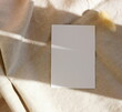 © irenastar - Blank paper with copy space , dry flower on beige linen texture  background with sunlight shadow top view. Card mockup,Greetings, wedding invitations blank, paper sheet.