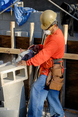 Wall Mural - Mason cutting concrete blocks on a construction site