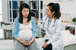 © PR Image Factory - asian female psychologist doctor is keeping hand on the depressed pregnant patient who is talking with a worried face expression on treatment bed in the clinic.