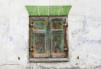 Old window with weathered closed shutters.