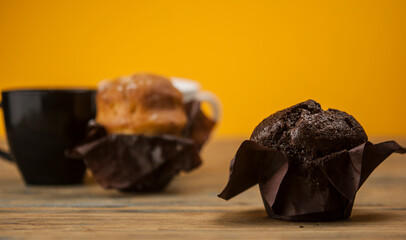 Wall Mural - Homemade chocolate and vanilla cupcakes on a wooden table, sprinkled with powdered sugar