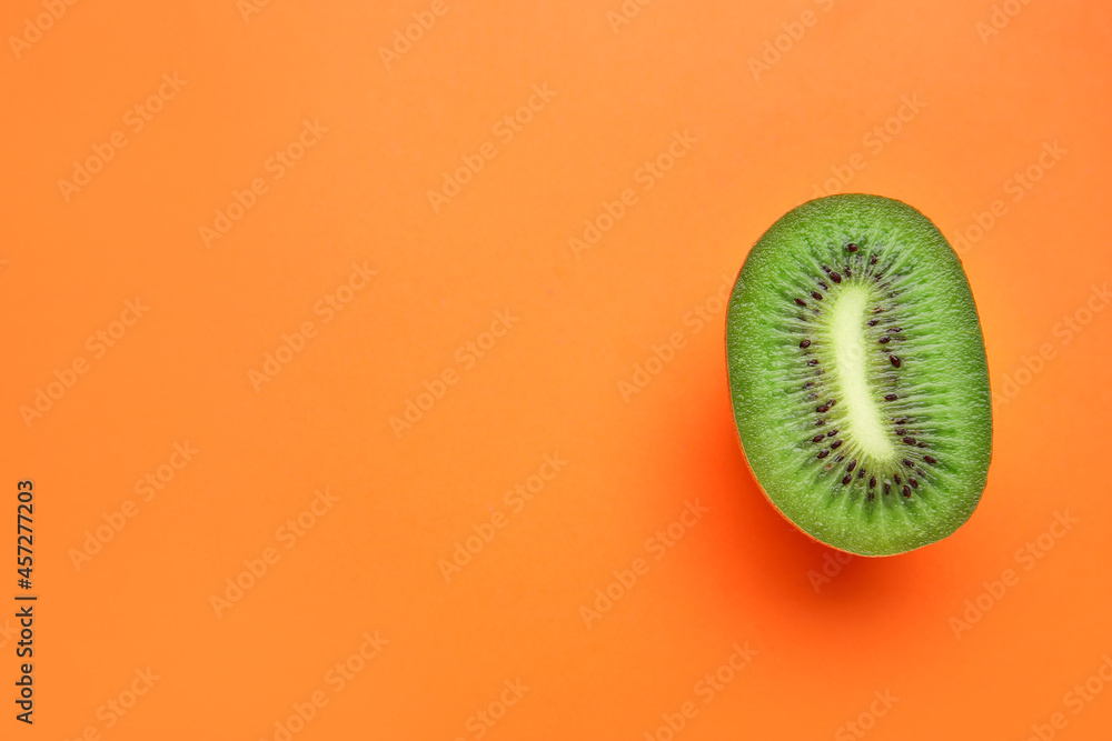 Piece of fresh kiwi fruit on color background