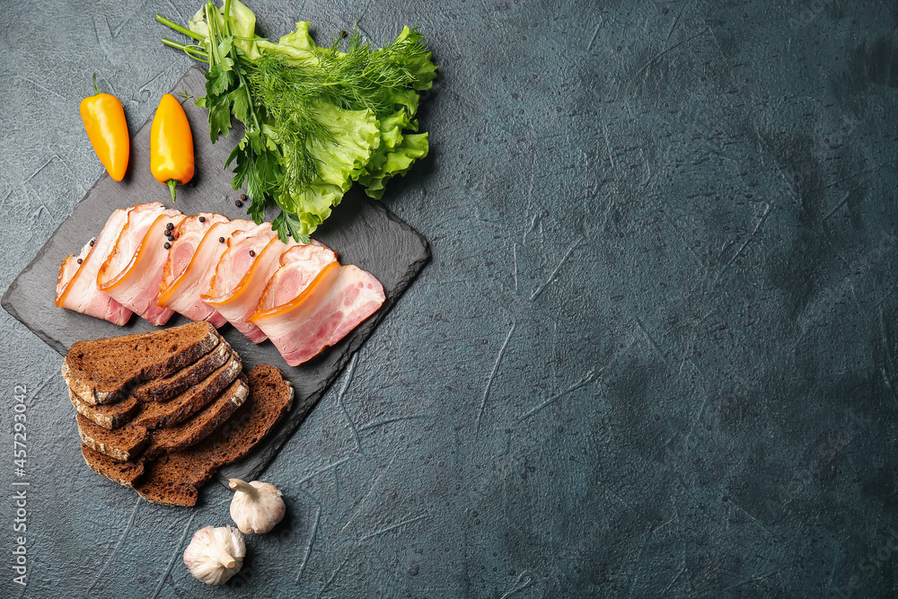 Composition with slices of tasty smoked bacon on dark background