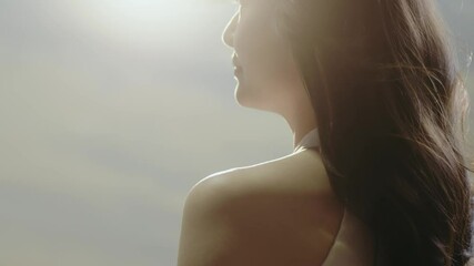 rear view of asian beauty standing with long hair flying in wind