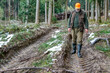 © BIB-Bilder - A hunter goes through his hunting area and looks worriedly at the deep lane left by the harvester.Even if the lane grows again the soil compaction remains.