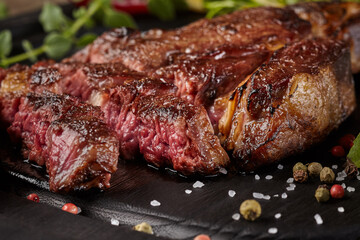 Closeup of sliced beef entrecote with condiments and greens