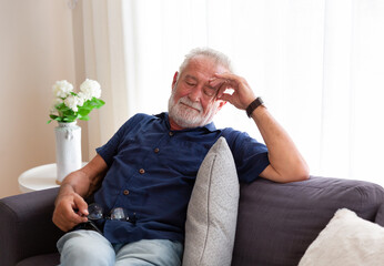 Wall Mural - Senior man sleeping on sofa at home. Elderly man relaxing at home