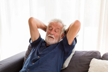 Wall Mural - Senior man sleeping on sofa at home. Elderly man relaxing at home