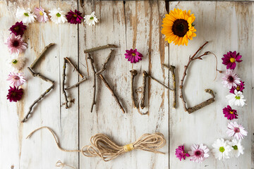  Spring rustic title with a frame full of flowers and a string on a white wooden background
