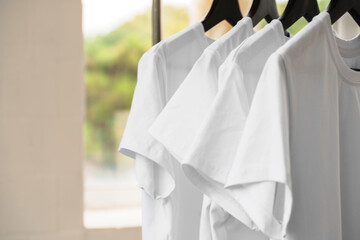 Poster - Row of white t-shirts on hangers on rack