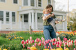 © Cavan Images - Mother playing with toddler son in backyard tulip garden in spri