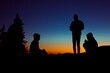© Cavan Images - Group of three people enjoy an evening while camping in the mountains