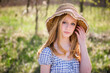 © Cavan Images - Beautiful teen blond girl outdoors in sundress and sun hat, backlit.