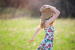 © Cavan Images - Beautiful teen blond girl outdoors in sundress and sun hat, backlit.