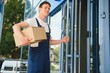© Serhii - happy delivery man with box