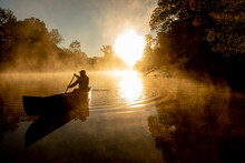 Sunrise Canoe Ride On Foggy River.
