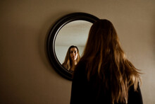 A Woman Looking At Herself In The Mirror
