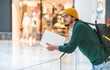 © Cavan Images - Modern spanish man with glasses and laptop posing in shopping mall