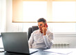 © Cavan Images - executive taking a call while working from his computer at home