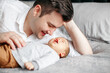 © Cavan Images - Fathers day holiday. Happy proud dad talking to newborn baby boy son