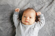 © Cavan Images - Cute two months newborn Asian Chinese baby boy lying on bed looking.