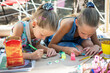 © Cavan Images - Girls paint with paints on wooden blanks. Street art festival
