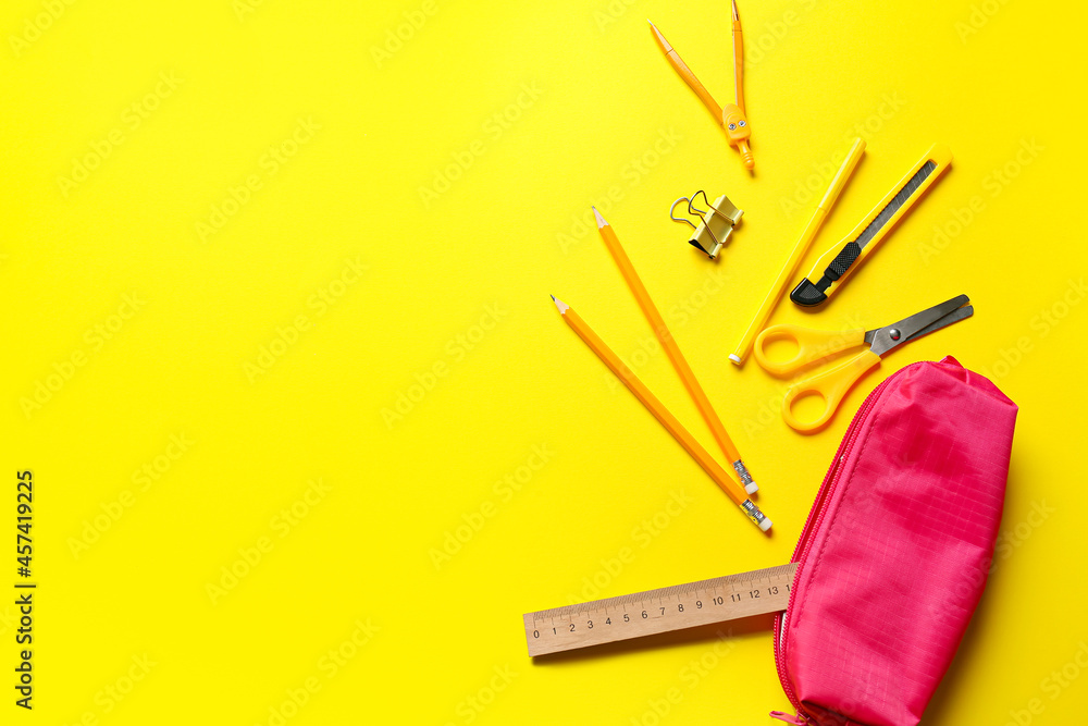 Stylish pencil case and stationery on yellow background