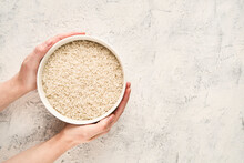 Top View Of Hands Holding A Bowl Of Raw White Rice With Copy Space