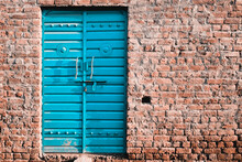 Closed Blue Metal Door Of A Brick Building