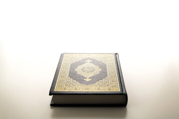 Islamic concept - The Holy Al Quran with written Arabic calligraphy meaning of Al Quran, Arabic word translation: The Holy Al Quran (holy book of Muslim), on white background, with copy space.