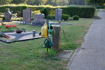 Wall Mural - FU 2020-08-11 Fries T2 91 Auf dem Friedhof ist ein Wasserspender mit Gießkannen