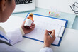 © DragonImages - Cardiologist analzying cardiogram of sick patient and prescribing bottle of medicine