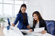 © DragonImages - Positive successful female entrepreneurs working on text of contract for upcoming meeting together