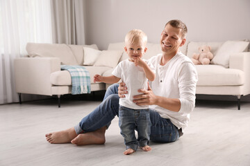 Wall Mural - Father with his cute little son in living room