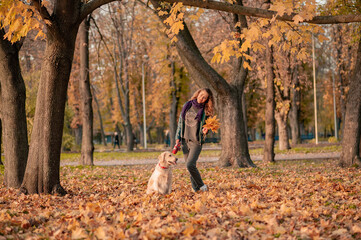 Wall Mural - Female woman with her dog in autumn leaves