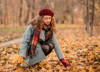 Dreamy beautiful girl with natural cutly hair on autumn background with colorful leaves.