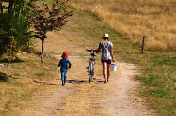 Canvas Print - Mother and son go home after picking blueberries.