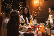 © Syda Productions - holidays, party and celebration concept - multiethnic group of happy friends having christmas dinner at home and drinking wine