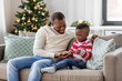 © Syda Productions - family, winter holidays and people concept - happy smiling african american father playing with baby son at home on christmas
