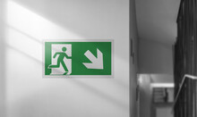 Emergency Exit Sign On A White Wall. Interior With Stairs.