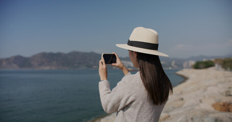 Poster - Woman use smart phone to take photo at landscape