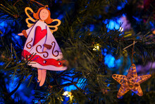 Decorative Star And Angel Hanging On Christmas Tree