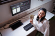 © ADDICTIVE STOCK - Smiling Asian trader cooling down with paper dollars against monitor