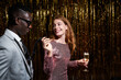 © ADDICTIVE STOCK - Stylish multiethnic couple with champagne talking during party