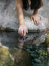 Crop Woman Touching Pure Water In Pond