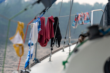 Clothes hanging to dry over the railing of a sailboat at dawn